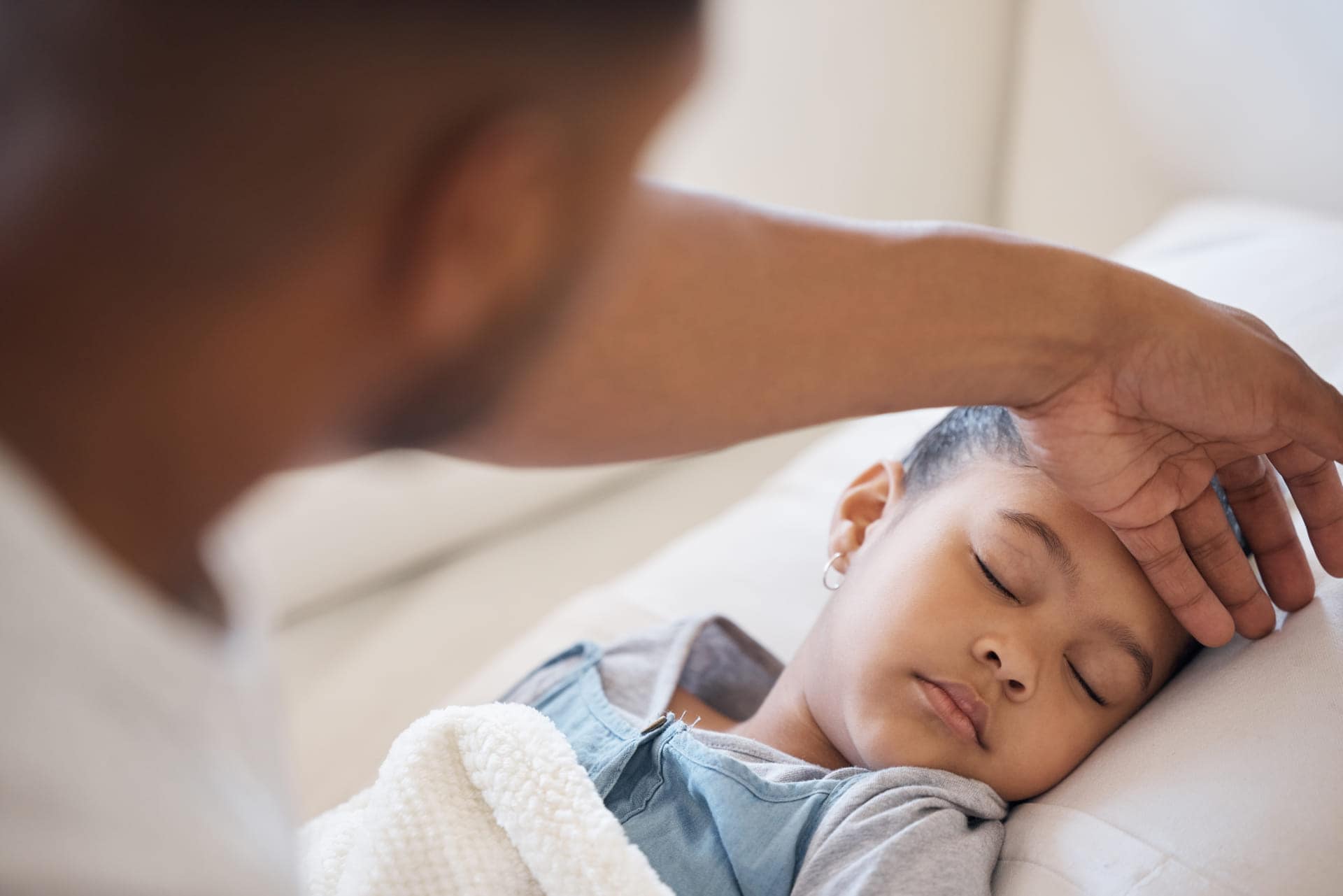 Parent checking on a child's fever